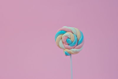 Close-up of multi colored candies against pink background