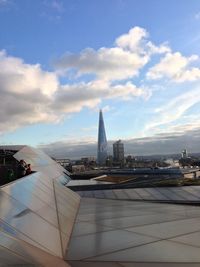 View of cityscape against cloudy sky