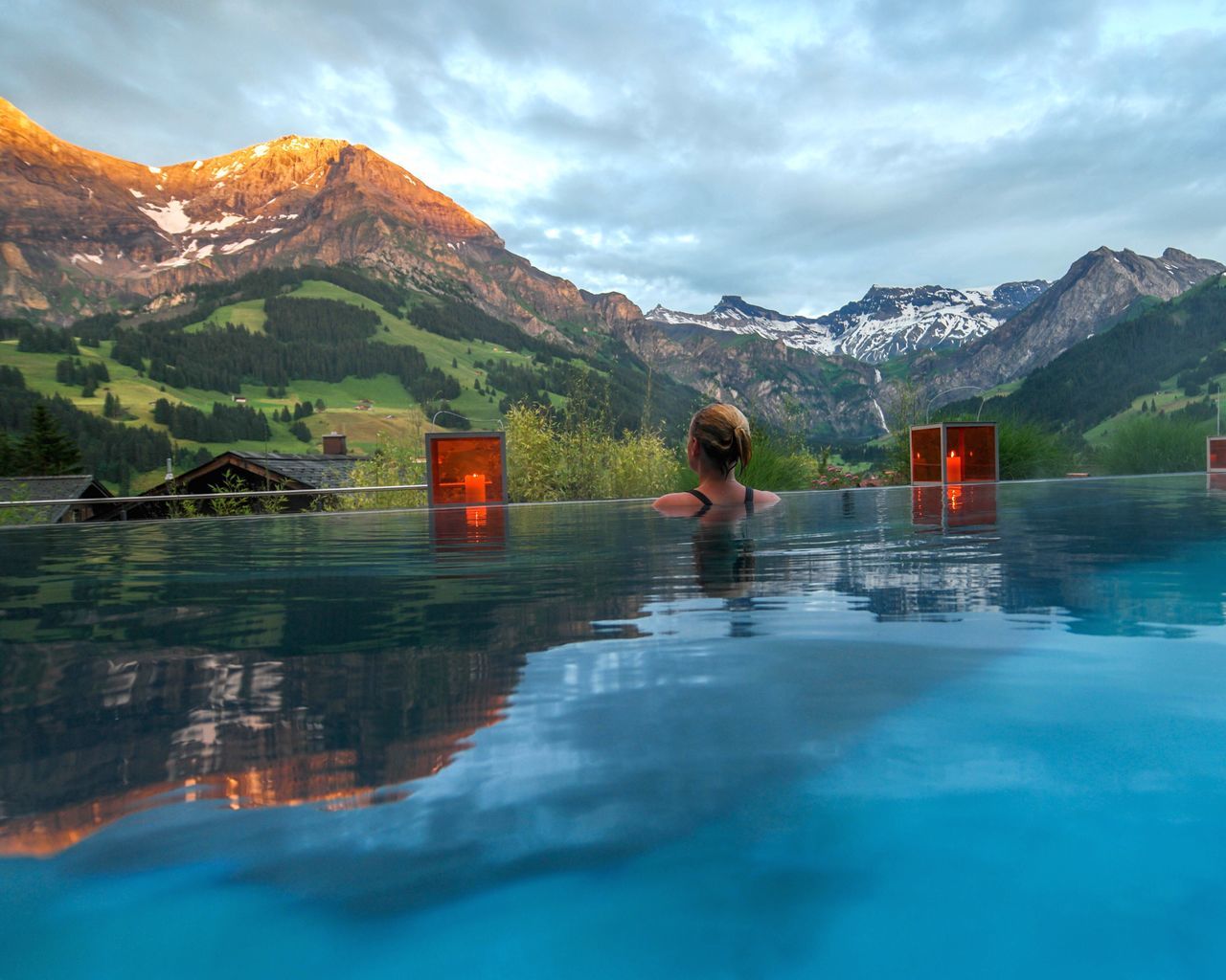 Woman swimming in pool by mountains against sky