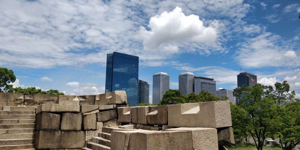 Buildings in city against cloudy sky