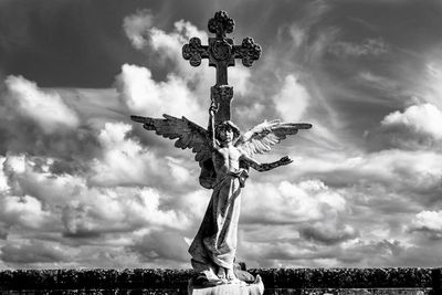 Low angle view of cross statue against sky