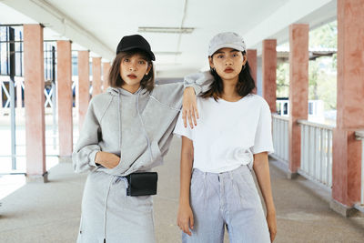 Portrait of young couple standing against wall