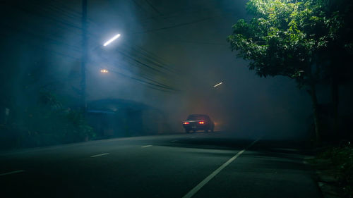 Car on illuminated street at night