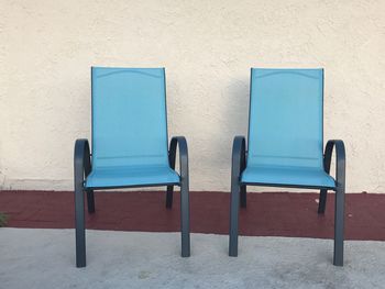 Empty chair against blue wall