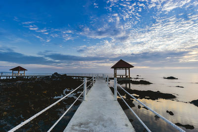 Lifeguard hut on beach against sky during sunset