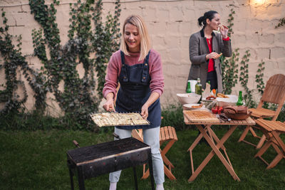 Portrait of woman using laptop while sitting on field