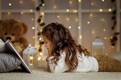 Side view of woman using digital tablet at home