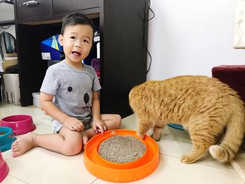 Portrait of cute boy playing with cat