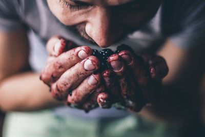 Close-up of man smelling blackberries