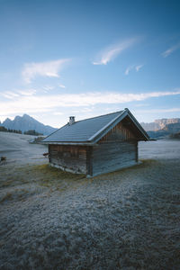 Hut on field against sky