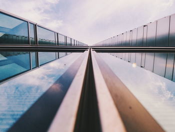 Bridge with reflection over river against sky