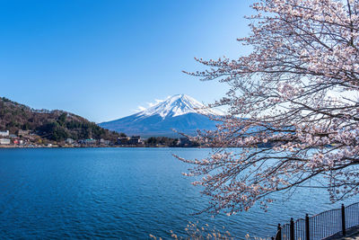 Scenic view of lake and mountains against clear blue sky