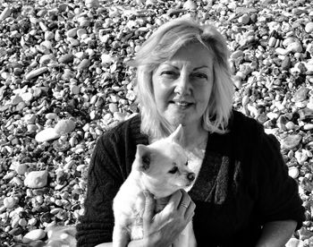 High angle portrait of woman with dog at beach