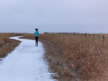 Rear view of woman standing on grassy field
