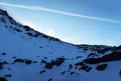 Low angle view of snow covered mountain against sky