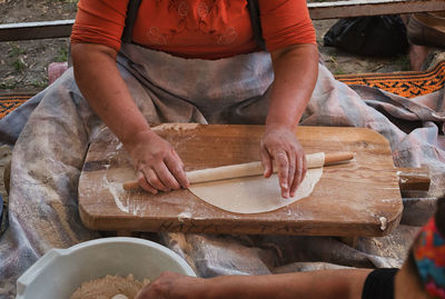 Midsection of woman rolling dough