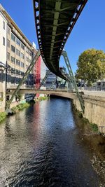 Arch bridge over river against sky in city