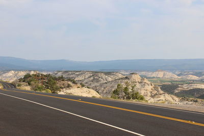 Road by mountains against clear sky