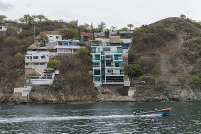 Buildings by sea against sky