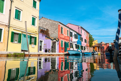 Boats in canal amidst buildings in city