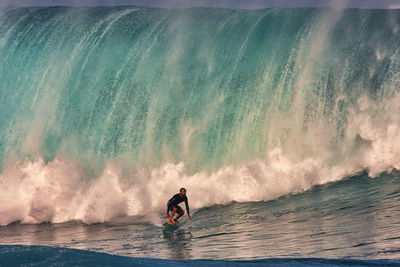 Man surfing in sea against sky