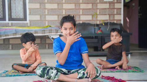 Asian kids doing yoga pose at home. group of children doing gymnastic exercises.