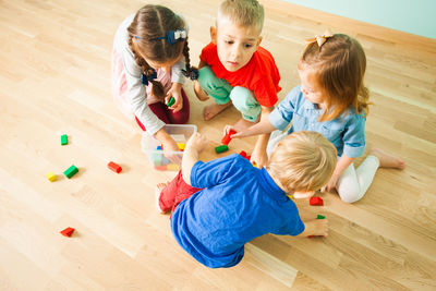 High angle view of people and stuffed toy on floor