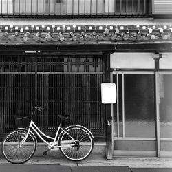 Bicycle parked on sidewalk by old japanese house.