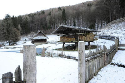 Snow covered cottage on field