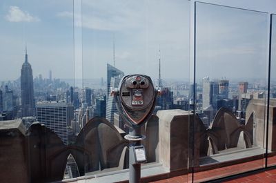 Coin-operated binoculars in building against sky