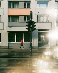 Man walking on street amidst buildings in city