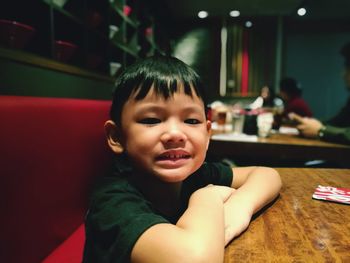 Portrait of smiling boy sitting at restaurant