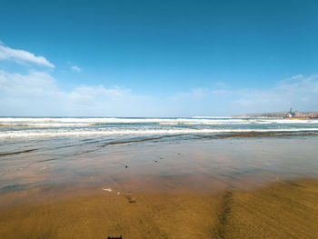 Scenic view of beach against blue sky