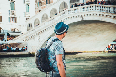 Man standing on bridge over canal