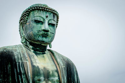 Close-up of buddha statue against clear sky