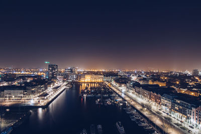 High angle view of illuminated buildings against sky at night