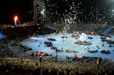 High angle view of people on illuminated shore against sky at night