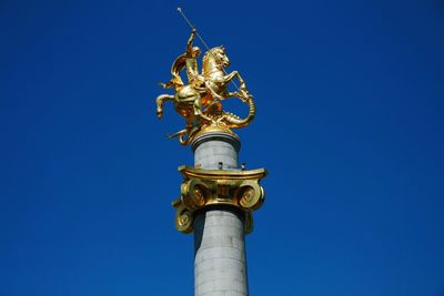 Low angle view of clock tower against blue sky