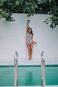 Portrait of woman standing by swimming pool