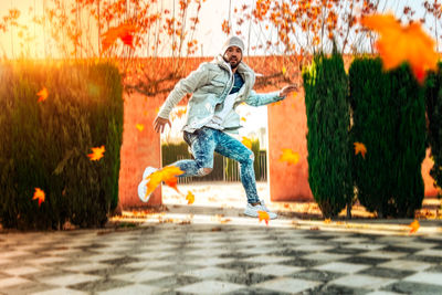 Full length of man jumping against plants