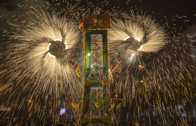 Low angle view of firework display at night