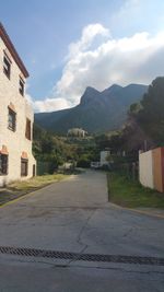 Houses on mountain against cloudy sky