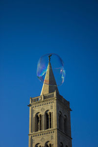 Low angle view of tower against blue sky