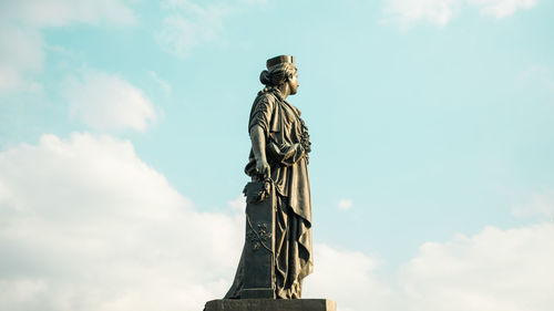 Low angle view of female monument against sky