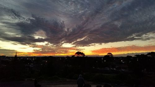 Silhouette landscape against dramatic sky during sunset