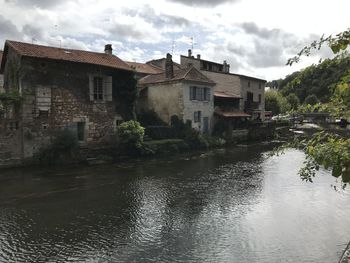 River by buildings against sky