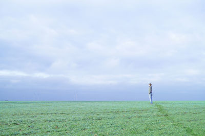 Rear view of person standing on grassy field