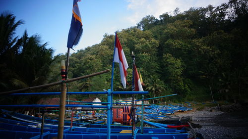 Multi colored flags on boat against sky