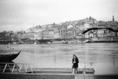 Rear view of man on riverbank against sky