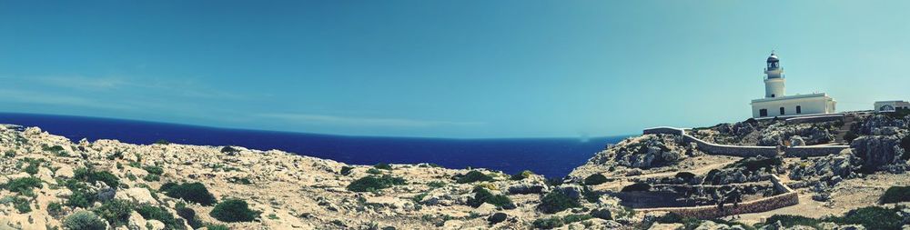 Panoramic shot of building by sea against blue sky